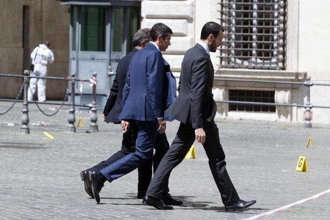 Il neoministro alle Infrastrutture Maurizio Lupi entra a palazzo Chigi mentre i carabinieri stanno effettuando i rilievi. Ansa